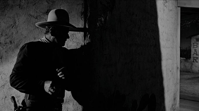 Persona con sombrero y ropa oscura apoyada en una pared en un ambiente con poca luz y un letrero que dice bar al fondo.

Description generated by AI